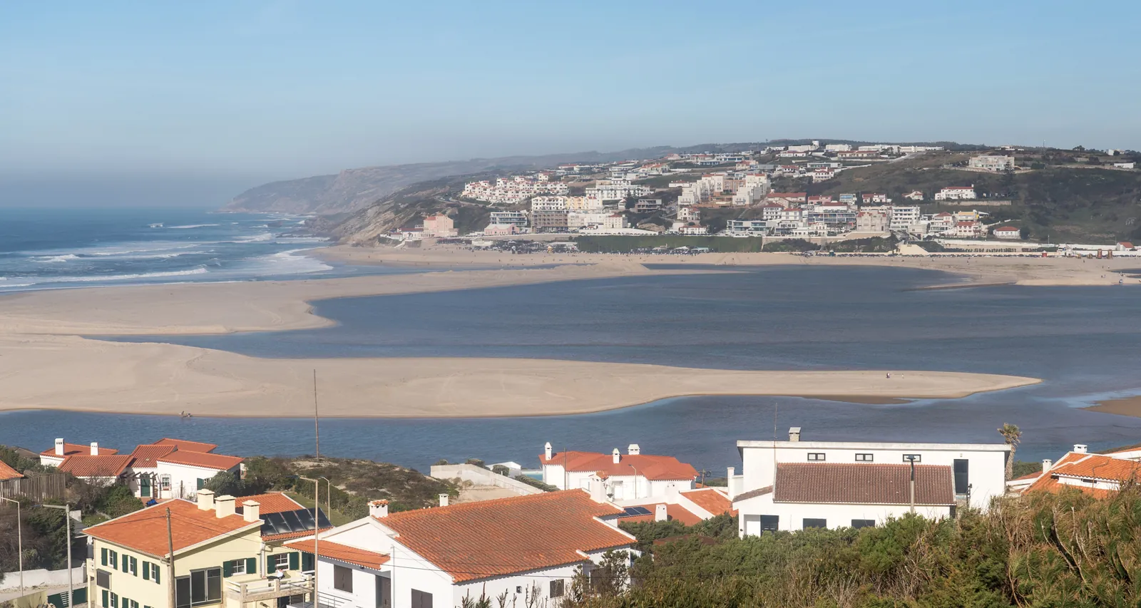 Sandbanks of the Óbidos Lagoon meeting the Atlantic surf below the hillside village of Foz do Arelho