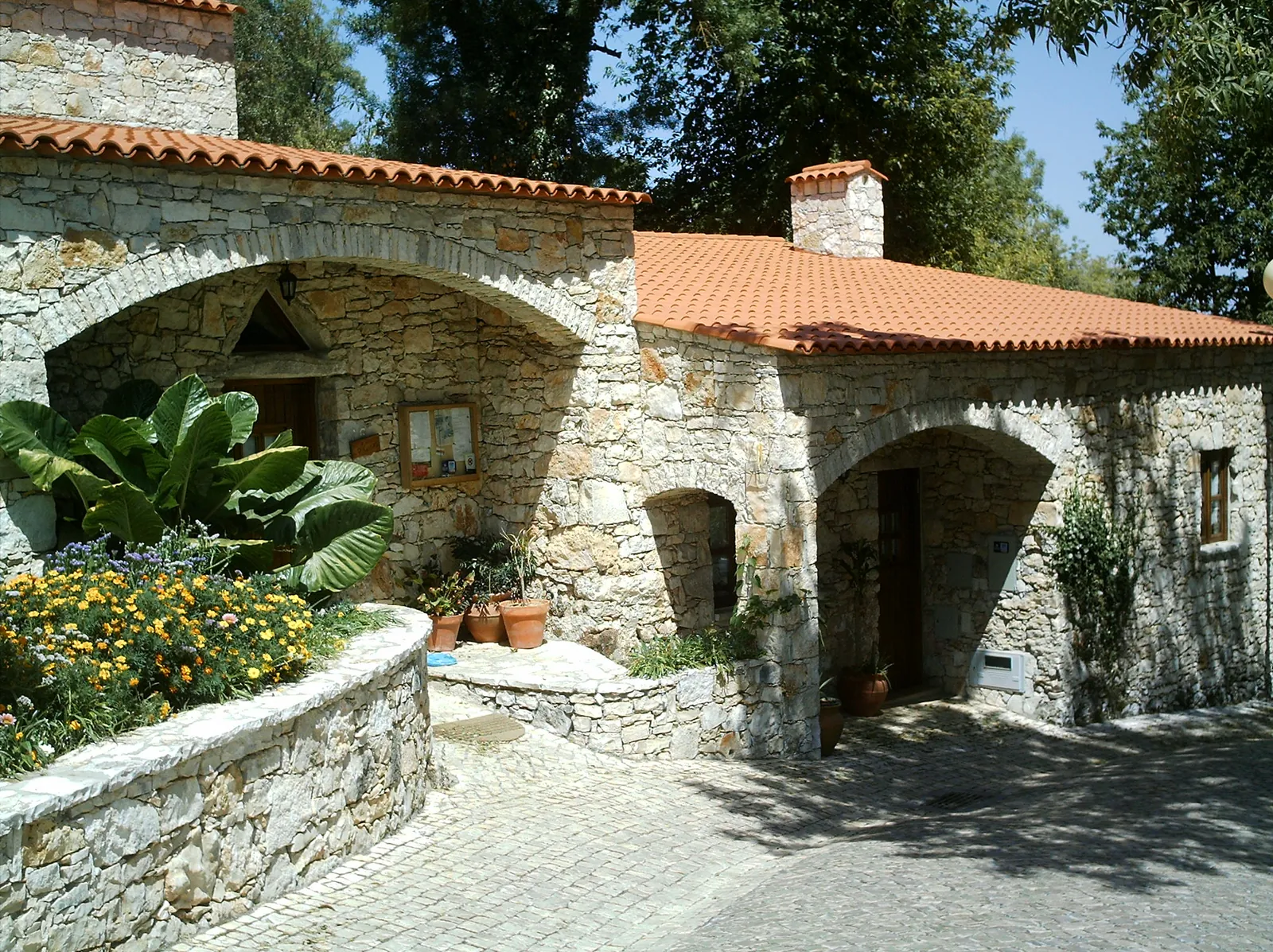 Restored limestone houses with arched doorways and terracotta roofs in the village of Pia do Urso