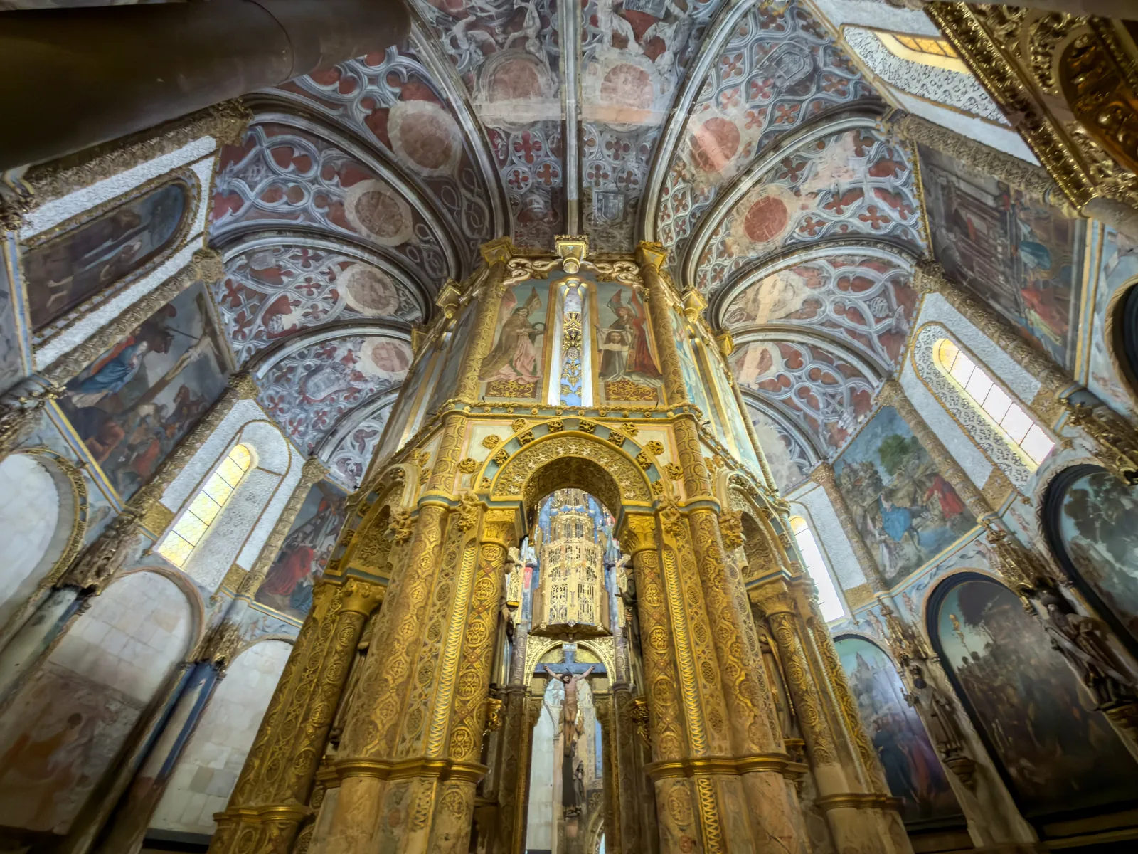 Gilded octagonal high altar of the Charola in Tomar's Convent of Christ, beneath painted vaults and Renaissance panels
