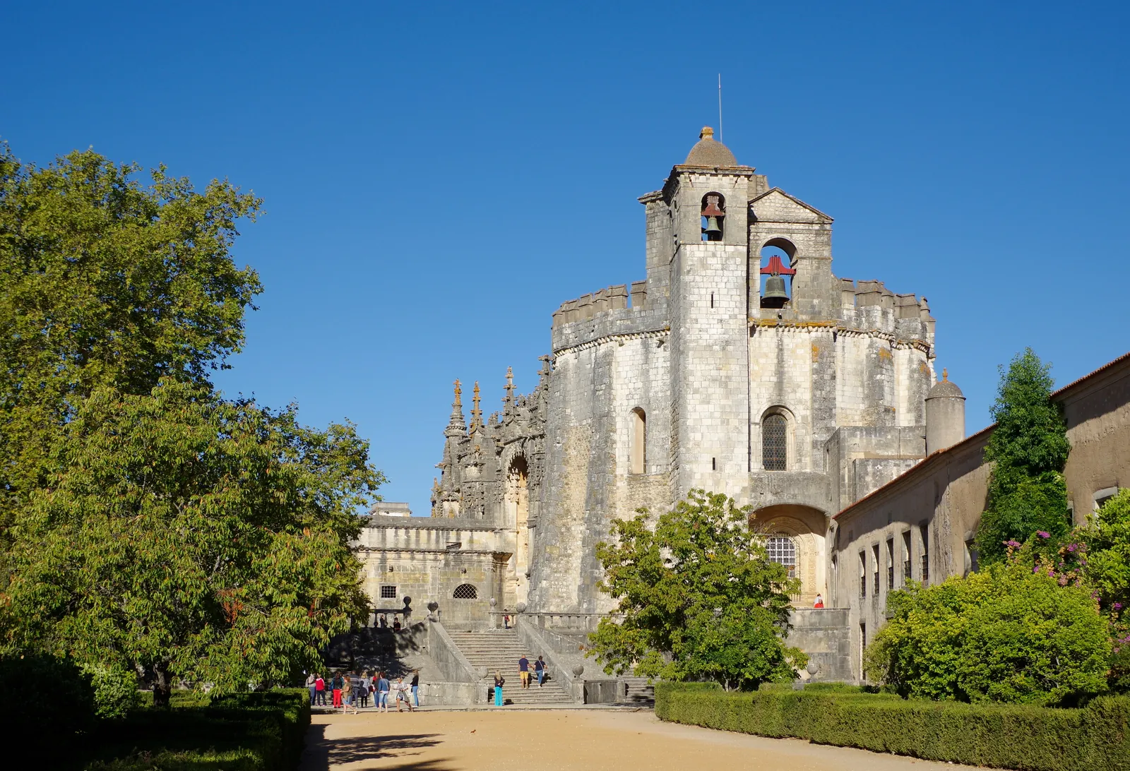 Fortified exterior of the Templar rotunda and bell tower of the Convent of Christ in Tomar under a clear sky